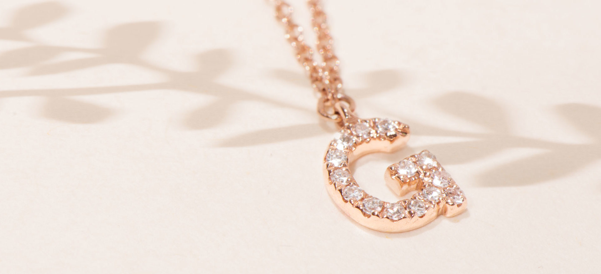 Frau trägt Buchstabenkette aus Gold mit Diamanten